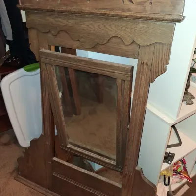 Sale Photo Thumbnail #42: Antique oak dresser mirror frame featuring a carved decorative crest with leaf motifs and a tilting center mirror.