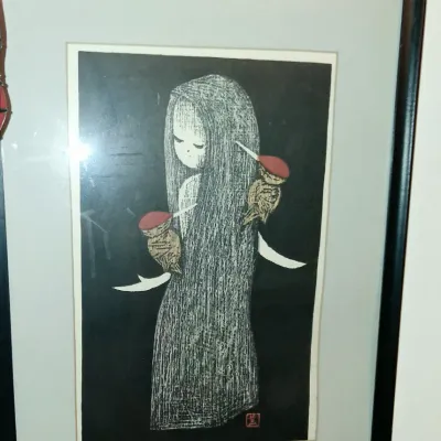 Sale Photo Thumbnail #7: Framed Japanese woodblock print by artist Shima Tamami, depicting a stylized figure in a textured cloak, presented in a simple black frame.