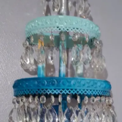 Sale Photo Thumbnail #98: Vintage-style wall sconce featuring tiered metal bands painted in shades of blue and teal, adorned with hanging glass crystal prisms.