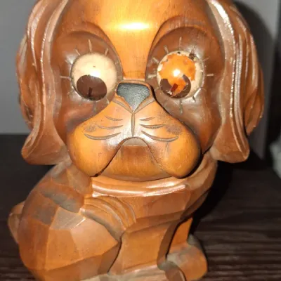 Sale Photo Thumbnail #129: Vintage carved wooden dog figurine with large googly eyes, showing some wear and discoloration on the left eye.