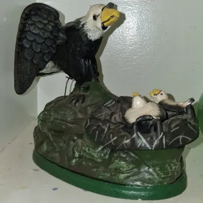 Sale Photo Thumbnail #12: Vintage cast iron mechanical bank featuring an eagle feeding its eaglets in a nest, with hand-painted details.