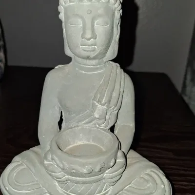 Sale Photo Thumbnail #130: Small cast stone or concrete Buddha statue in a seated meditative pose, holding a shallow bowl designed to function as a candle holder.