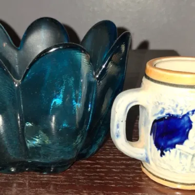 Sale Photo Thumbnail #119: Vintage teal glass lotus-style bowl alongside a small ceramic beer stein featuring a blue relief scene.