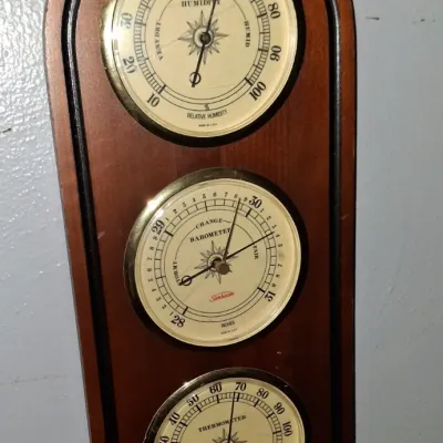 Sale Photo Thumbnail #4: Vintage Sunbeam wall-mounted weather station featuring a humidity gauge, barometer, and thermometer set in an arched wooden frame.