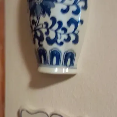 Sale Photo Thumbnail #88: Two vintage blue and white ceramic wall pockets, including a Chinoiserie floral vase design and a Delft-style pocket featuring a windmill scene.