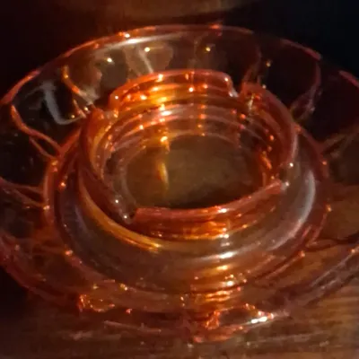 Sale Photo Thumbnail #108: Vintage amber glass ashtray set, featuring a smaller inner ashtray nested within a larger matching outer dish.