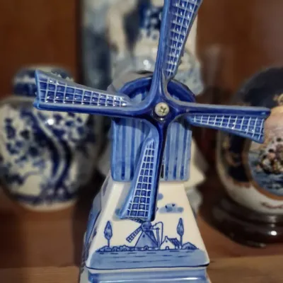 Sale Photo Thumbnail #105: Delft Blue style ceramic windmill figurine featuring hand-painted details and "Holland" inscribed on the base.