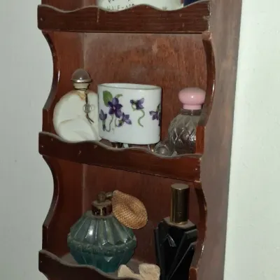 Sale Photo Thumbnail #30: Vintage wooden wall-mounted knick-knack shelf holding various small items, including miniature porcelain dishes with violet patterns and vintage perfume bottles.