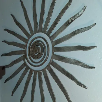 Sale Photo Thumbnail #143: Mid-century modern brutalist metal sunburst wall sculpture featuring a central spiral design with radiating wavy rays.
