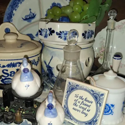 Sale Photo Thumbnail #62: Collection of vintage blue and white kitchenware, featuring a salt crock, Delft-style windmill warmer, glass decanters, and ceramic chicken figurines.