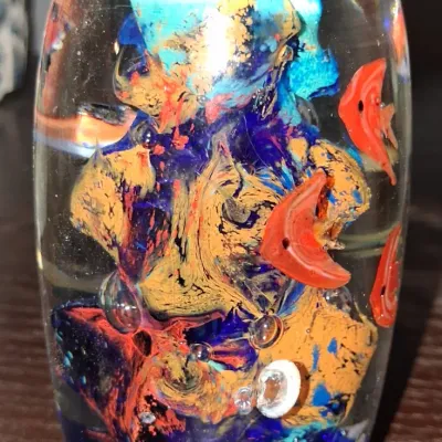 Sale Photo Thumbnail #124: Vintage art glass paperweight featuring an underwater scene with orange fish, coral-like formations, and controlled bubbles.