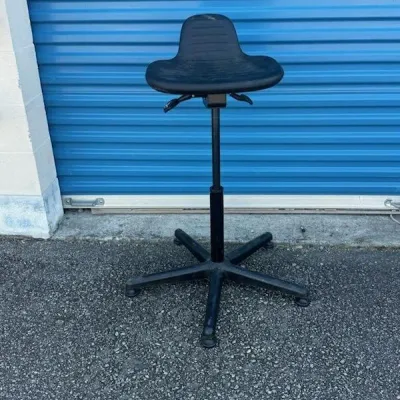 Sale Photo Thumbnail #37: Ergonomic black sit-stand stool with adjustable height lever and a five-star base.