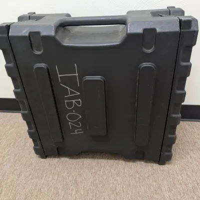 Sale Photo Thumbnail #279: Heavy-duty black molded plastic equipment transit case with integrated handle, showing some surface wear and hand-written labeling.
