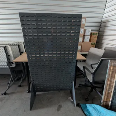 Sale Photo Thumbnail #13: Freestanding metal louvered panel organizer in dark gray, suitable for hanging storage bins and tools.