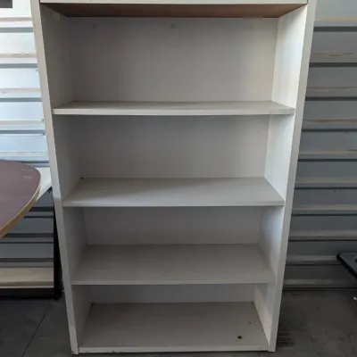 Sale Photo Thumbnail #30: White laminate five-shelf bookcase showing some minor wear and dust from storage.