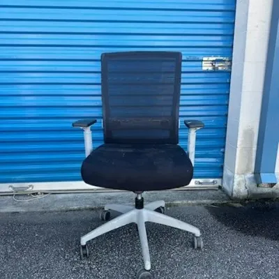 Sale Photo Thumbnail #26: Modern ergonomic office chair featuring a black mesh back, upholstered seat cushion, and a five-star wheeled base with adjustable armrests.