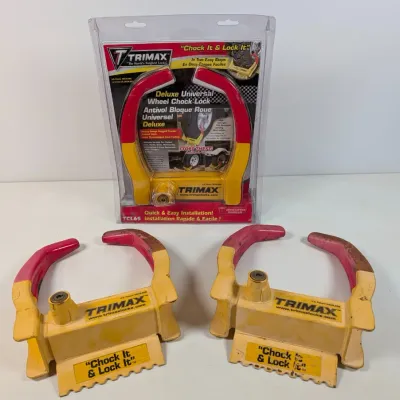 Sale Photo Thumbnail #327: Trimax Deluxe Universal Wheel Chock Lock, model TCL65, shown in its original packaging alongside two loose, used units of the same model.