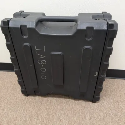 Sale Photo Thumbnail #280: Heavy-duty black molded plastic equipment transit case with integrated handle, showing some surface wear and handwritten markings.