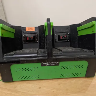 Sale Photo Thumbnail #225: Green and black dual-bay PowerCharge Station, showing some light dust and wear from use.