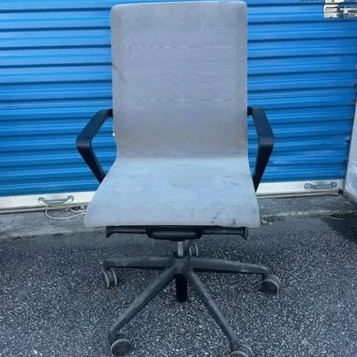 Sale Photo Thumbnail #41: Modern gray fabric office chair with black armrests and a five-star caster base, showing some wear and dust.