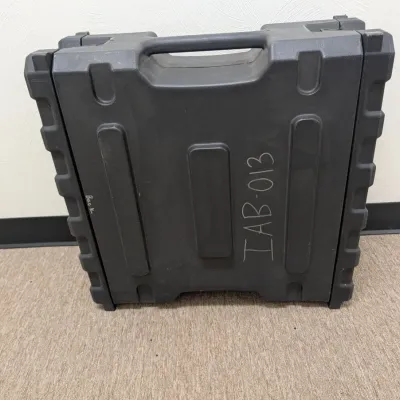 Sale Photo Thumbnail #287: Heavy-duty black plastic equipment transit case with integrated carrying handle and handwritten markings on the side.