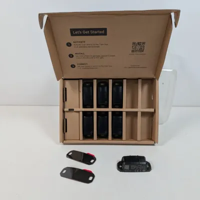Sale Photo Thumbnail #167: Samsara asset tracking devices in their original cardboard packaging, with several units and mounting plates displayed.