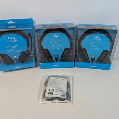 Sale Photo Thumbnail #303: Three Logitech USB computer headsets in original packaging, including one H390 model and two H540 models, accompanied by a small accessory pack.