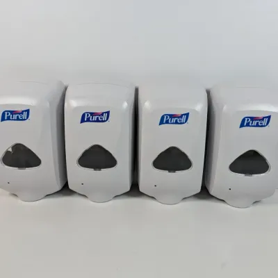 Sale Photo Thumbnail #114: Four wall-mounted Purell hand sanitizer dispensers in white plastic, showing light wear.