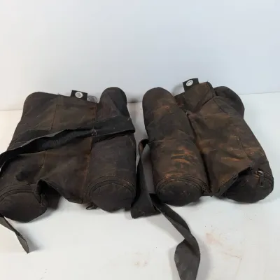 Sale Photo Thumbnail #294: Pair of heavily used black canvas saddle sandbags with carrying straps, showing significant dirt and wear from use.