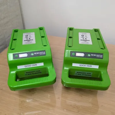 Sale Photo Thumbnail #232: Pair of Newcastle Systems green portable power pack batteries, labeled "GOOD 2026" and showing light wear.