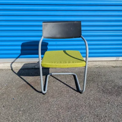 Sale Photo Thumbnail #60: Modern cantilever office chair featuring a grey tubular metal frame, a black plastic backrest, and a lime green upholstered seat cushion.