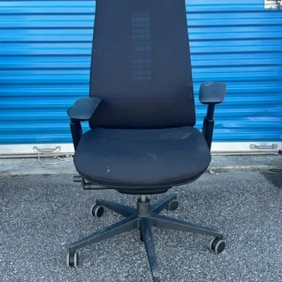 Sale Photo Thumbnail #38: Modern black mesh high-back office chair with adjustable armrests and a five-star caster base, showing some light wear.