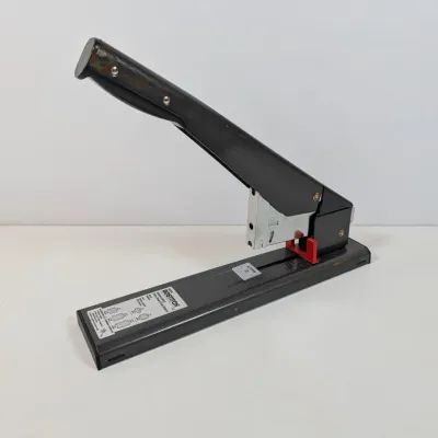 Sale Photo Thumbnail #301: Bostitch heavy-duty lever-action stapler in black metal finish, showing light wear from use.