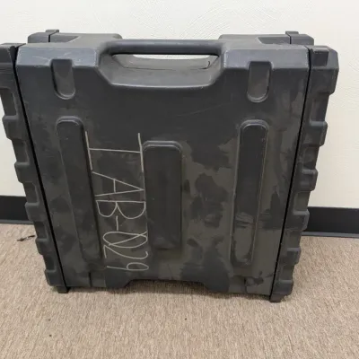 Sale Photo Thumbnail #285: Heavy-duty black plastic hard-shell equipment case with integrated handle, showing some surface wear and marked with white lettering.