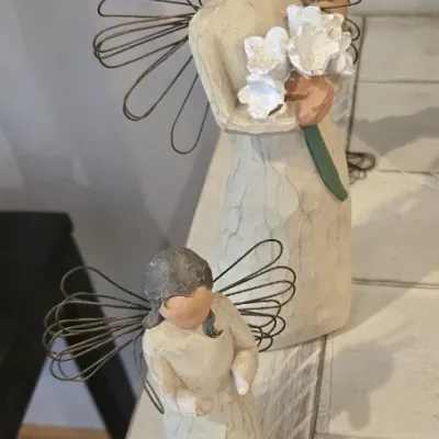 Sale Photo Thumbnail #44: Two Willow Tree angel figurines of varying sizes, featuring wire wings and carved-wood style resin designs.