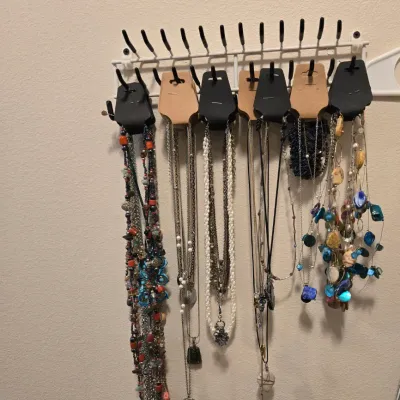 Sale Photo Thumbnail #38: Assortment of beaded and pendant necklaces displayed on a wall-mounted jewelry organizer.