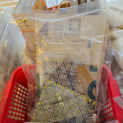 Assorted quilting templates, patterns, and acrylic rulers, including an Omnigrid triangle ruler, packaged together in a clear plastic bag.