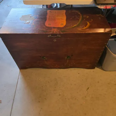Sale Photo Thumbnail #84: Vintage Lane cedar chest with hand-painted floral details and original paper label on the lid, showing some wear and finish loss.