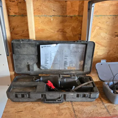 Sale Photo Thumbnail #114: Black & Decker Professional reciprocating saw in its original hard plastic carrying case, showing signs of use.