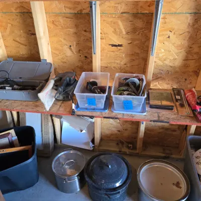 Sale Photo Thumbnail #111: Assorted workshop tools and kitchenware, including power tools on wooden shelves and large cooking pots on the floor.