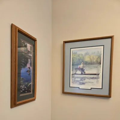 Sale Photo Thumbnail #61: Two framed art prints featuring serene lakeside scenes, including a vertical print of a loon on a lake and a matted print titled "Great Expectations" depicting figures fishing from a dock.
