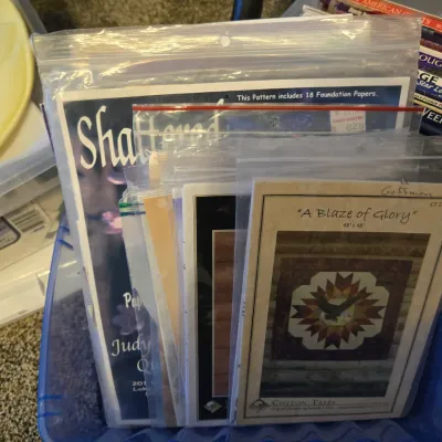 Sale Photo Thumbnail #22: Collection of quilting patterns in plastic sleeves, including "Shattered" by Judy Niemeyer and "A Blaze of Glory" by Cotton Tales.