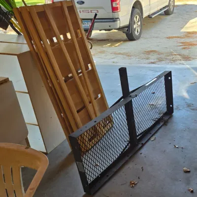 Sale Photo Thumbnail #85: Black metal hitch-mounted cargo carrier with mesh floor, shown alongside wooden slats and other garage items.