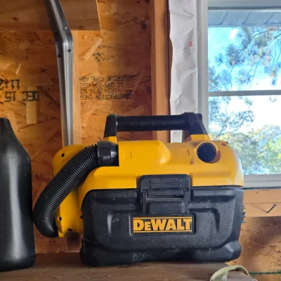 Sale Photo Thumbnail #98: DeWalt portable wet/dry vacuum with integrated hose and carrying handle, showing light wear from garage use.