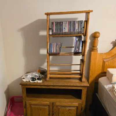 Sale Photo Thumbnail #55: Oak media cabinet with lower double doors and an open shelf, topped with a matching wooden CD and DVD storage rack.