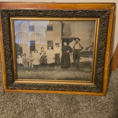 Sale Photo Thumbnail #36: Antique black and white family portrait photograph, housed in an ornate, heavily carved wooden frame with gold-painted accents.