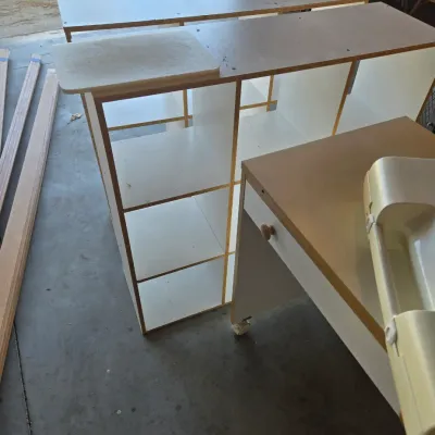 Sale Photo Thumbnail #103: White laminate shelving units and a rolling desk with a single drawer, showing some wear from use.