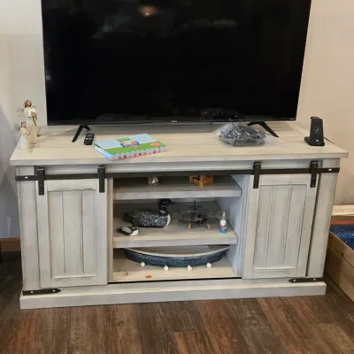Sale Photo Thumbnail #41: Modern farmhouse-style media console in a whitewashed finish, featuring sliding barn-style doors, black metal hardware, and open center shelving.