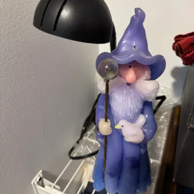 Sale Photo Thumbnail #174: Vintage novelty wizard candle in purple robes, holding a staff and a small white bird.