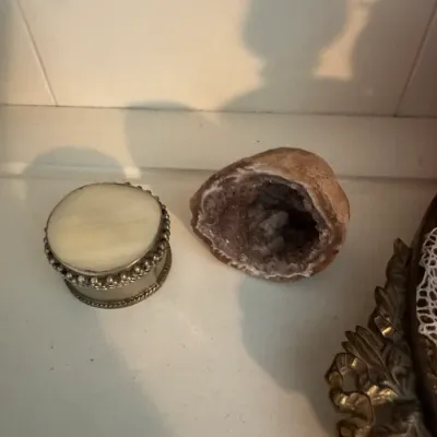 Sale Photo Thumbnail #194: Small vintage round trinket box with a beaded metal rim and an alabaster or stone lid, shown next to a natural quartz geode specimen.